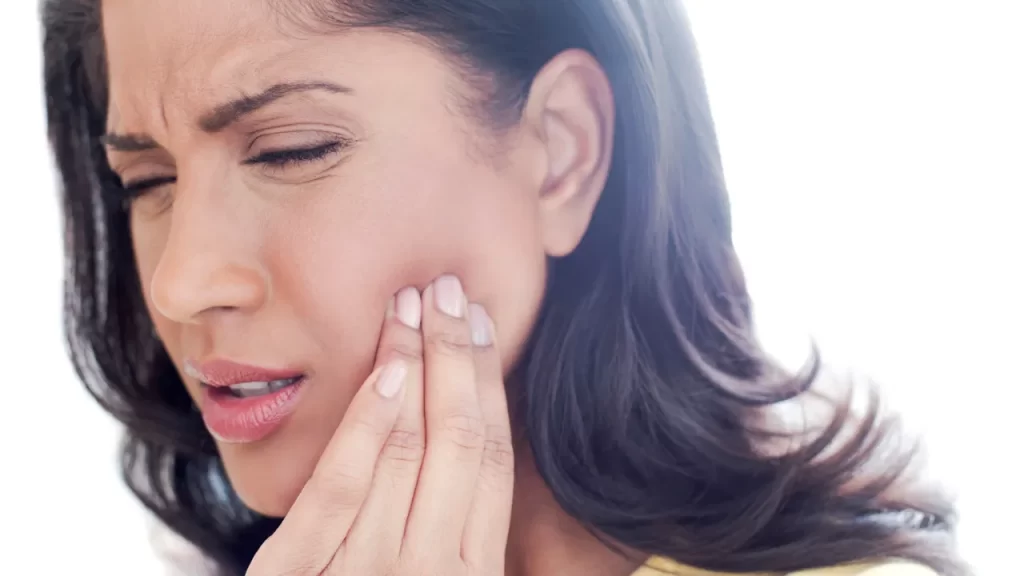 woman holding her cheek showing tooth ache